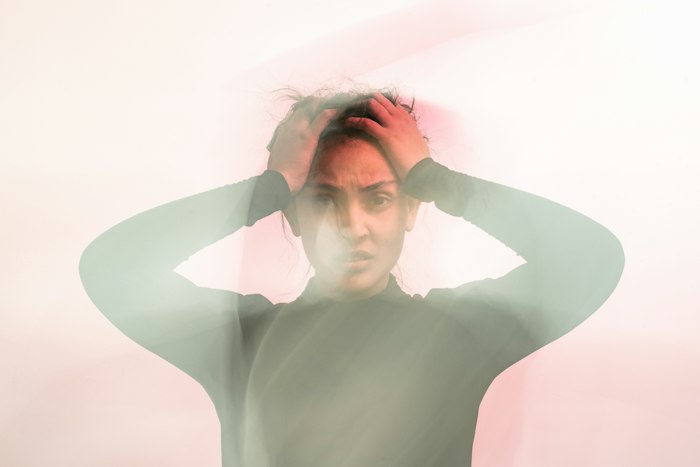 Woman holding her head with tension